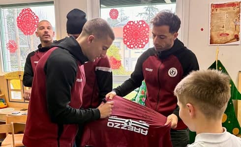 i giocatori dell'arezzo con un bambino ricoverato in pediatria